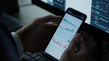 Businessman analyzing financial charts on smartphone during late-night work for market analysis photo