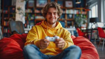 Smiling young man sits in a beanbag chair, holding a game controller photo