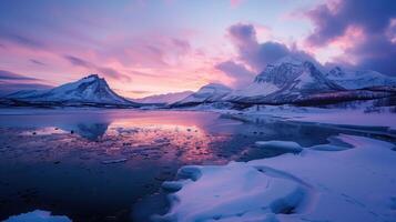 The colors of a stunning sunset are mirrored in the icy surface of a mountain lake photo