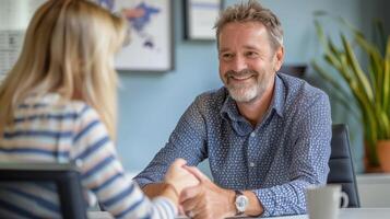 Mature businessman is holding a client's hands reassuringly during a meeting at the office photo