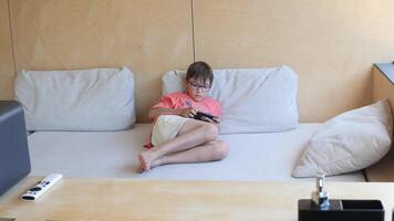 Young boy lying on a couch is using a smartphone in six consecutive frames video