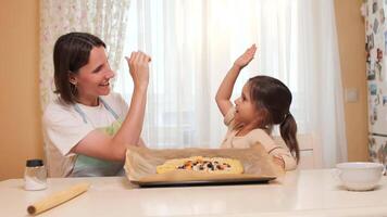 Mother and daughter baking together and celebrating with high-five video