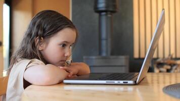 Young girl sitting at desk is concentrating while working on laptop computer video