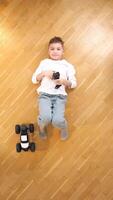 vertical boy lying on his back controls toy rc car with a remote control video