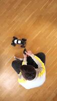 vertical top view of a man playing with a model of a radio-controlled car video