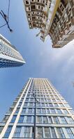 loop circular motion and view up from ground to blue sky among skyscrapers, look at house from bottom up video