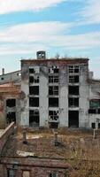 Aerial view of an old factory ruin and broken windows. Old industrial building for demolition. Vertical video