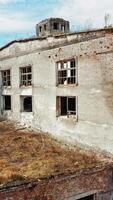 Aerial view of an old factory ruin and broken windows. Old industrial building for demolition. Vertical video
