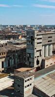 Abandoned building. Aerial view of an old factory ruin and broken windows. Vertical video