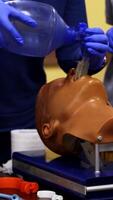 Training session of giving first aid. Person does the training reanimation procedure on a dummy with breathing system. Vertical video