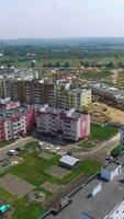 Flying above new residential complex in the city in summer. Panoramic top view of modern buildings built in the new district. Aerial view Vertical video