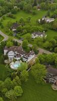 Beautiful private mansions located in the green suburb. Lovely houses connected with roads and paths and surrounded by greenery. Top view. Vertical video