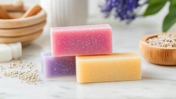 Colorful handmade soaps arranged on a marble counter with natural ingredients nearby photo