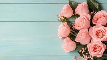Soft pink roses arranged on a turquoise wooden surface with scattered petals photo