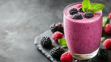 Berry smoothie with mint leaves served on a slate plate photo