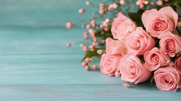 Soft pink roses arranged on a turquoise wooden surface with scattered petals photo