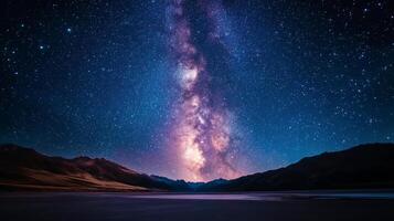 Starry night sky over calm lake surrounded by mountain ranges at twilight photo