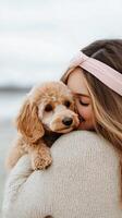 Girl embraces her fluffy dog on the beach at sunset photo