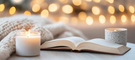 Cozy evening reading with candles and soft blanket by glowing lights photo