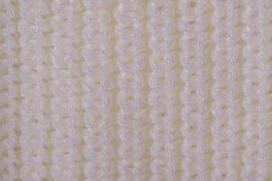Knitted light background. Part of knitted clothes macro photo. photo