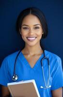 Healthcare worker in blue scrubs holding a medical chart against a dark background photo