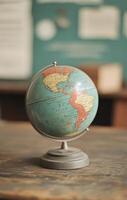 Vintage globe resting on a wooden table in a classroom setting photo