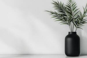 Black vase with green palm leaves on a minimalistic white background photo