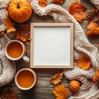 Wooden frame surrounded by autumn leaves and pinecones on a rustic wooden surface photo