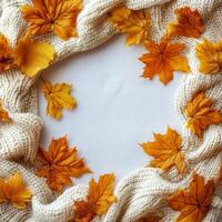 Wooden frame surrounded by autumn leaves and pinecones on a rustic wooden surface photo