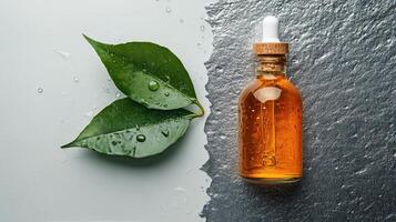 Natural oil dropper bottle with fresh green leaves on textured surface photo
