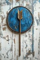 Arrow hitting blue and white target on weathered wooden surface photo