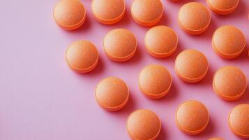 Orange tablets arranged on a pink surface in a vibrant, modern setting photo