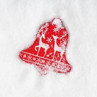 Red Christmas decoration with white reindeers and snowflakes on snowy background. Minimal creative Christmas and New year concept. Trendy festive winter holidays layout. Flat lay, top of view. photo
