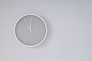 Gray and white wall clock on gray background. Time concept. Minimal Christmas eve or New Year idea. Flat lay composition. photo