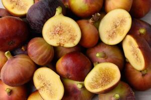 A cluster of ripe figs neatly arranged side by side on a surface photo