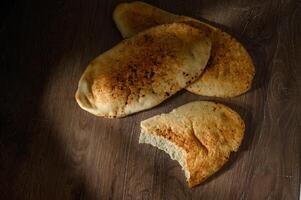 pita bread on a wooden board Summer Mediterranean theme food side border. Top down view on a wood banner background with copy space photo