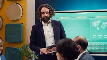 Project manager welcoming his team in business meeting, shaking hands. Supervisor explains the overall enterprise goals, analyzing the current situation and works through planning details. Camera A. photo