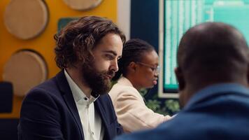 Team of associates working on resource allocation plans during a meeting, making important budgeting and staffing decisions to corelate with company objectives. Employees review strategies. Camera A. photo