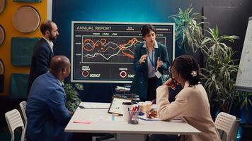 Skilled project team reviewing annual reports market trends in briefing meeting, knowing what to improve in order to guarantee customer experience and satisfaction. Enterprise development. Camera B. photo