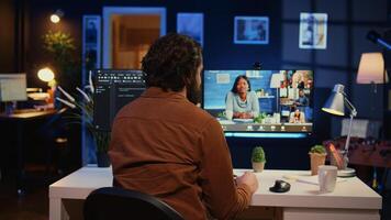 Teleworking software engineer talking with colleagues during internet videocall, discussing ways to fix programming bugs. IT admin in videoconference meeting with coworkers, camera B photo