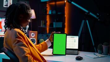 University student looking at greenscreen on tablet learning to use cash plan software, studying business and finances with online classes. Looks at copyspace, conducting data analysis. Camera B. photo