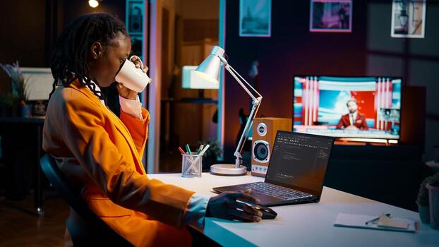 African american it specialist working with coding language and infographics, improving server security on terminal window. Young programming student learning to use code and hardware. Camera B. photo