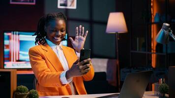 African american student attending online career course in videocall, using smartphone to meet remotely with classmates and professor. Pupil discussing about assignments with tutor. Camera A. photo