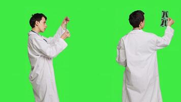 General practitioner examining radiography scan against greenscreen backdrop, looking at x ray results to find diagnosis. Physician in white coat uses radiology science and research. Camera B. photo