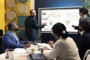 Team of business associates discussing ways to increase revenue in an executive meeting, analyzing statistics to conclude project. Enterprise workers collaborating to achieve goals. photo