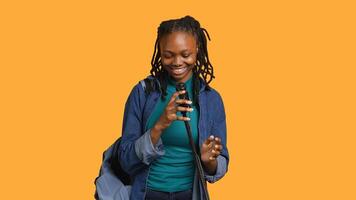 African american motivational speaker talking in microphone, addressing audience, holding speech, studio background. Inspiring woman using mic to present life lectures, camera A photo