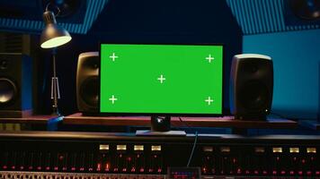 Empty professional recording studio control room with greenscreen on display, editing and processing tracks. Motorized faders, buttons and sliders operated for mix and master techniques. Camera B. photo