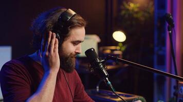 Sound producer recording backing vocals to add over tunes in home studio, using a mixing console to create a modern mix. Music producer mastering a new soundtrack with equalizer tool. Camera A. photo