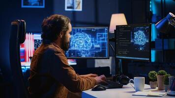 Software developer writes code on multimonitor setup PC to visualize artificial intelligence neural networks. Teleworking IT employee runs AI script on computer from home office, camera A photo