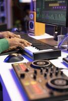 Sound designer recording his electronic piano notes in home studio, plays midi controller song and adds effects on recordings before launching music. Artist uses synthesizer and amplifier. Close up. photo